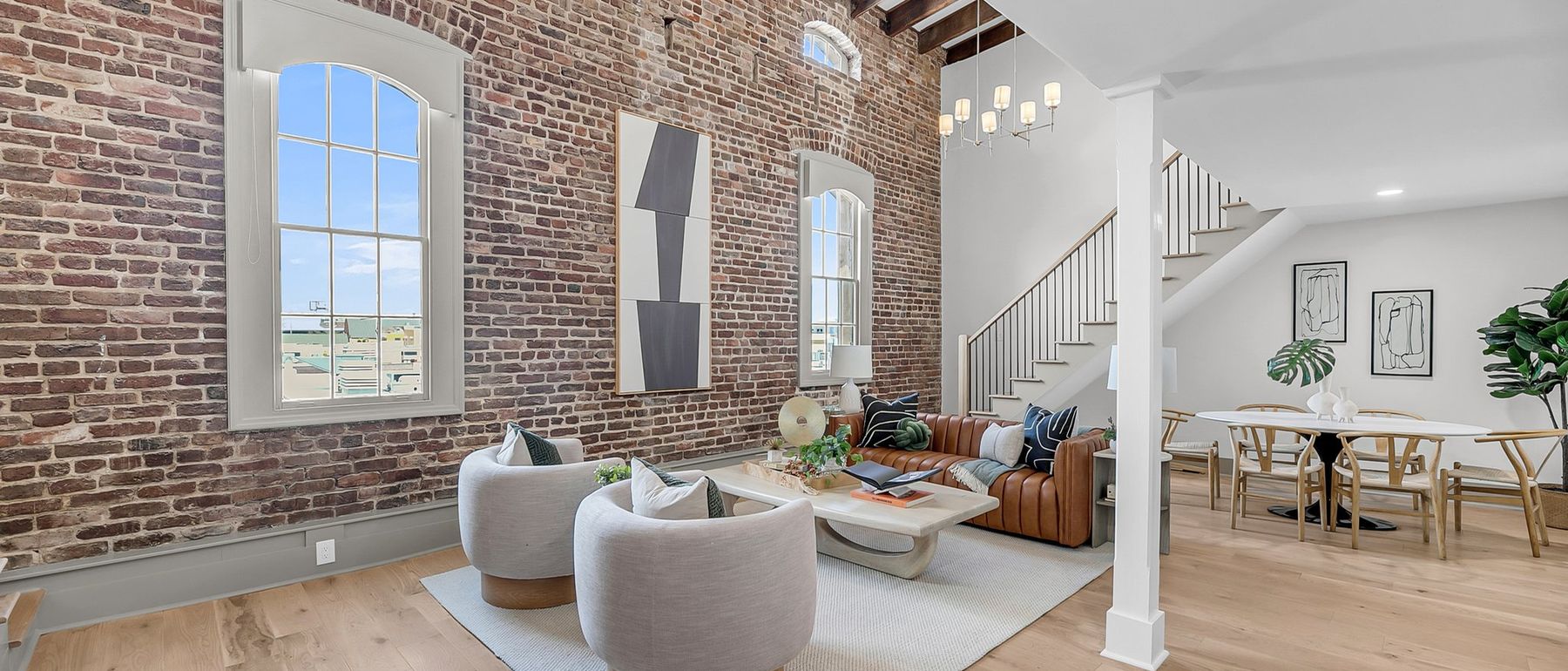 A restored Charleston loft with exposed brick walls, original beams and tall arched windows